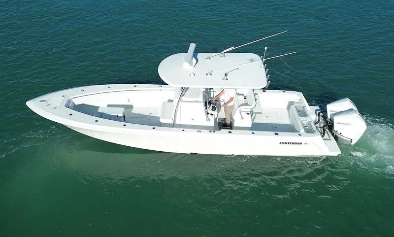 Slide: The Image of 2023 Contender 32 ST boat cruising on clear blue water. - 2