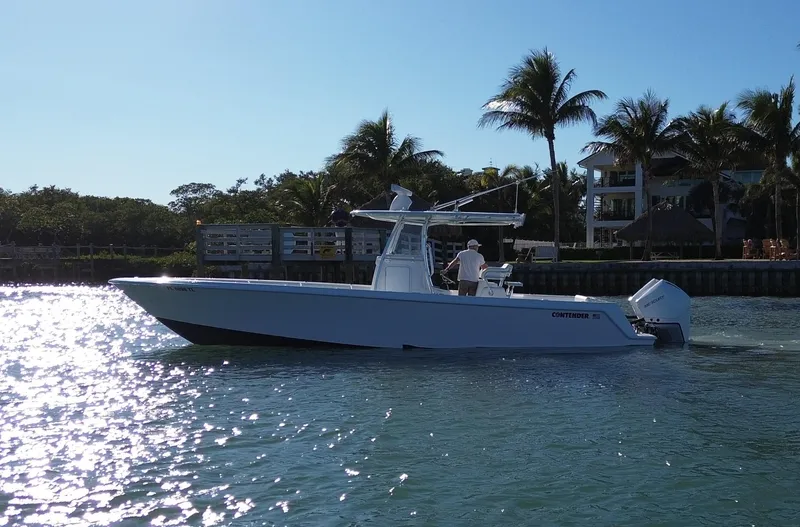 Slide: The Image of 2023 Contender 32 ST boat cruising on a sunny day near palm trees. - 22