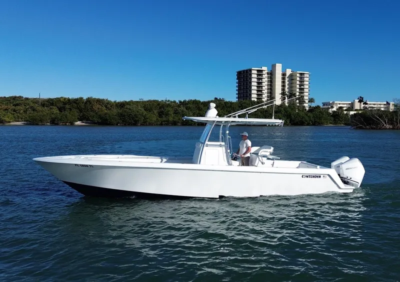 Slide: The Image of 2023 Contender 32 ST boat on water, clear sky, buildings in background. - 3