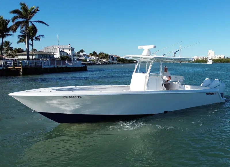 Slide: The Image of 2023 Contender 32 ST boat cruising on a sunny waterway. - 4