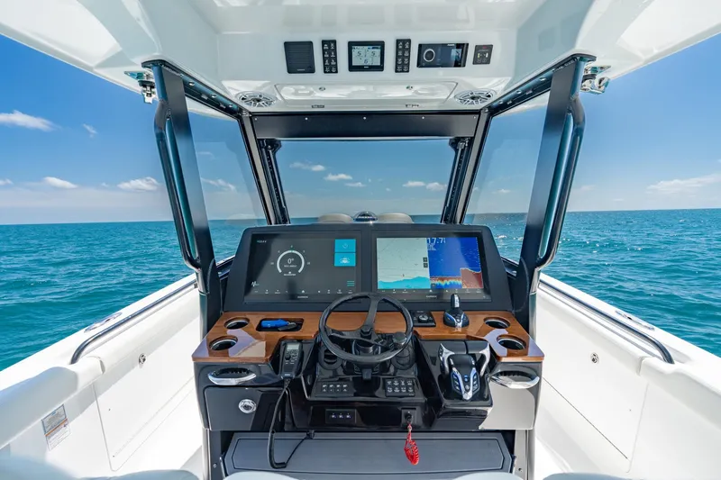 Slide: The Image of 2025 Everglades 375 Center Console boat dashboard with ocean view, featuring advanced navigation technology. - 11