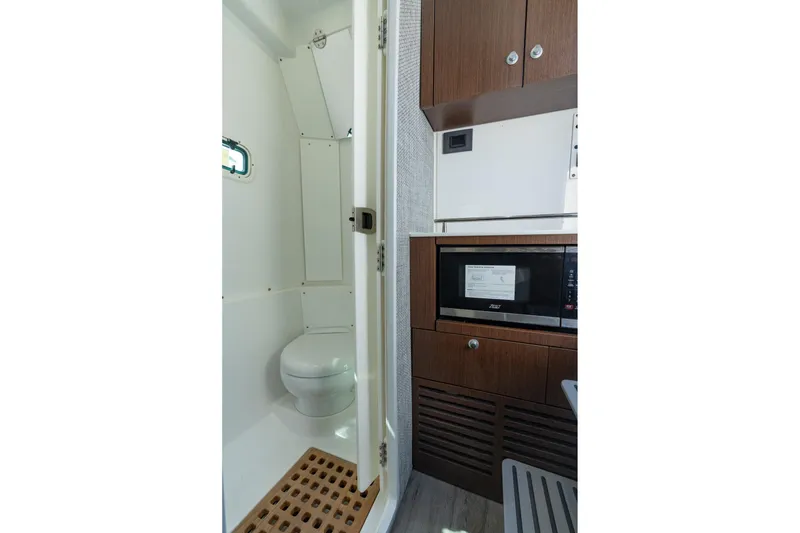 Slide: The Image of 2025 Everglades 375 Center Console interior with modern bathroom and kitchenette. - 27