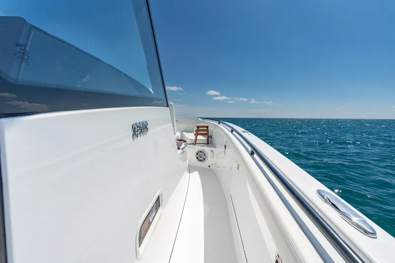 Slide: The Image of 2025 Everglades 375 Center Console boat cruising on open sea under clear blue sky. - 7