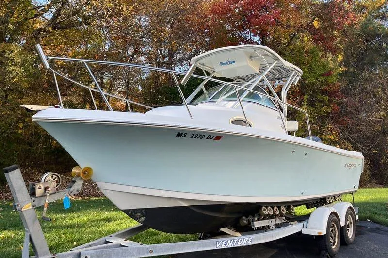 The Image of 2005 Sailfish 218 WAC boat on trailer, surrounded by autumn foliage. - 0