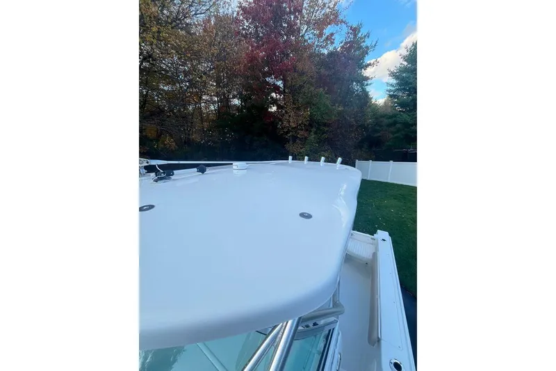 Slide: The Image of 2005 Sailfish 218 WAC boat deck, surrounded by autumn trees and a clear sky. - 14