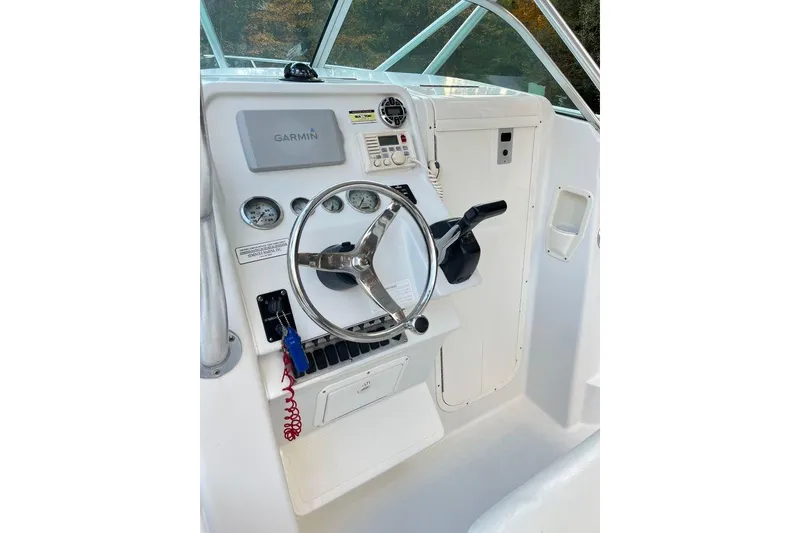 Slide: The Image of 2005 Sailfish 218 WAC boat helm with Garmin navigation and steering wheel. - 16