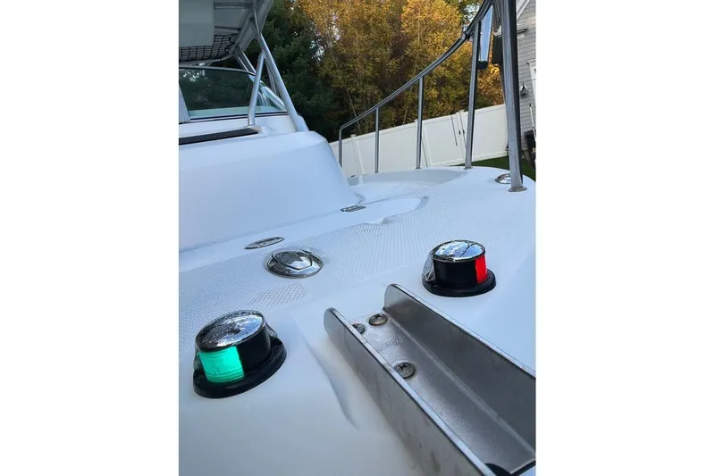 Slide: The Image of 2005 Sailfish 218 WAC boat deck with navigation lights and railing, surrounded by trees. - 22