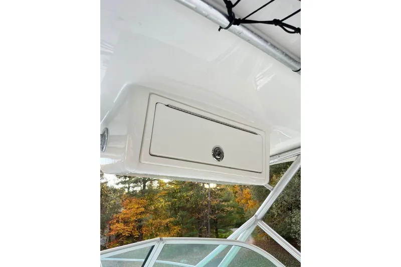 Slide: The Image of 2005 Sailfish 218 WAC boat interior storage compartment with autumn foliage background. - 25