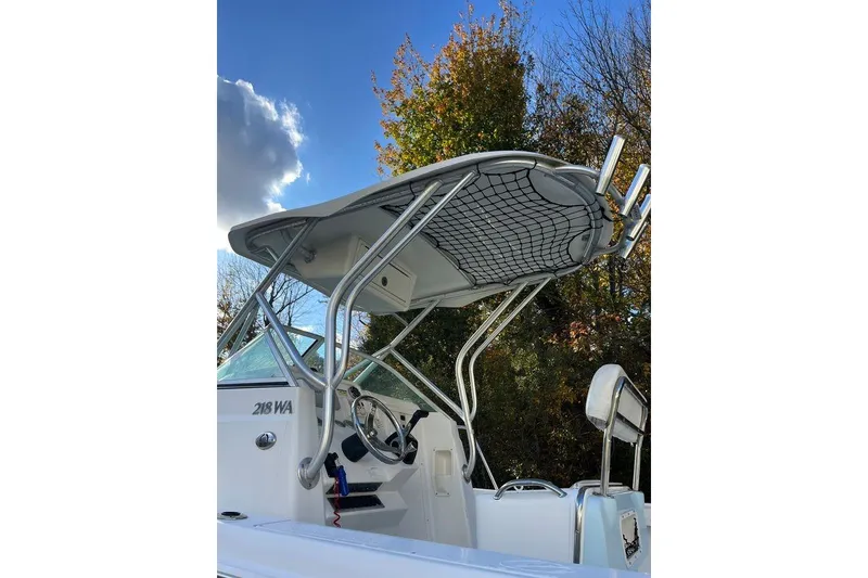 Slide: The Image of 2005 Sailfish 218 WAC boat with T-top and steering wheel, set against a leafy backdrop. - 29
