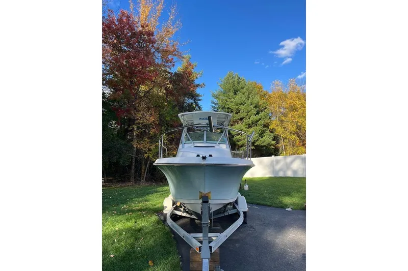 Slide: The Image of 2005 Sailfish 218 WAC boat on trailer, surrounded by autumn trees and clear blue sky. - 3