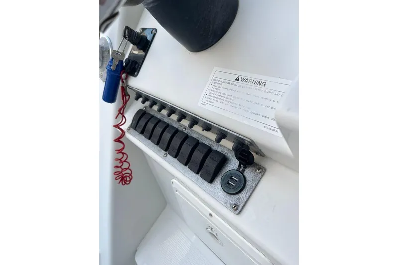 Slide: The Image of Control panel of a 2005 Sailfish 218 WAC boat with switches and warning label. - 37