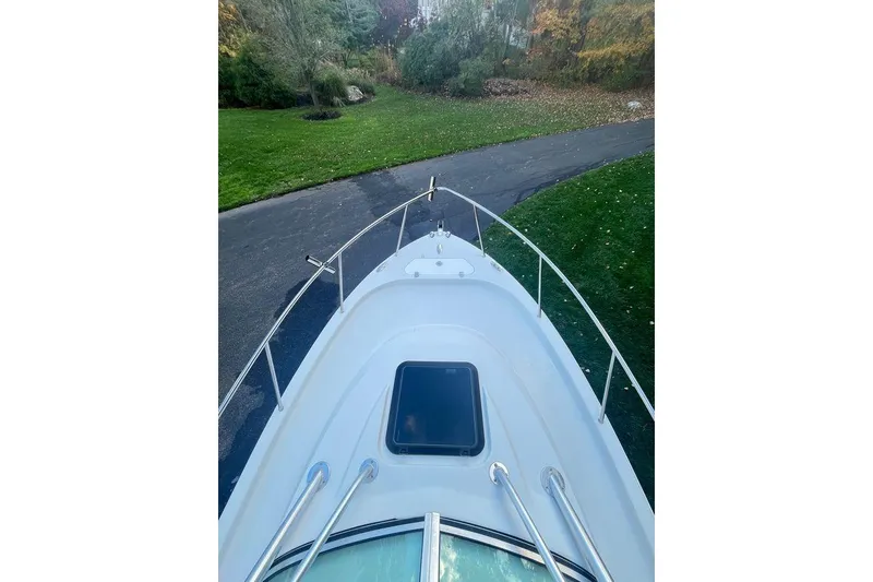 Slide: The Image of 2005 Sailfish 218 WAC boat bow view with railing, parked on driveway. - 4