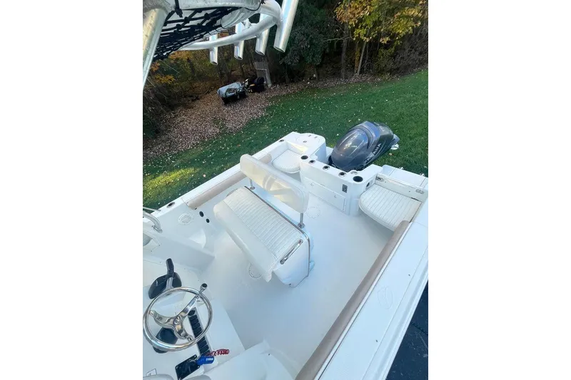 Slide: The Image of 2005 Sailfish 218 WAC boat interior with seating and steering wheel, parked on grass. - 47