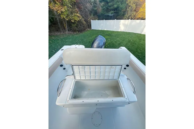 Slide: The Image of 2005 Sailfish 218 WAC boat interior with open storage compartment, surrounded by greenery. - 49