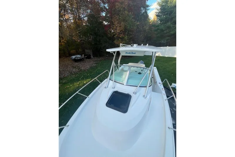 Slide: The Image of 2005 Sailfish 218 WAC boat on grassy yard, surrounded by trees. - 5