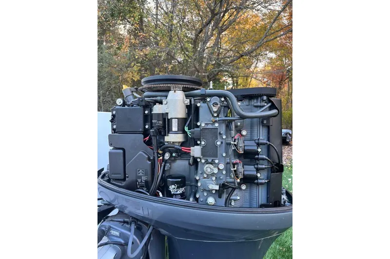 Slide: The Image of 2005 Sailfish 218 WAC boat engine, detailed view, surrounded by autumn foliage. - 56