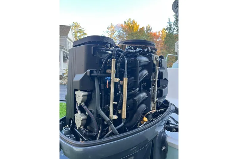 Slide: The Image of 2005 Sailfish 218 WAC boat engine, detailed view with surrounding autumn foliage. - 58