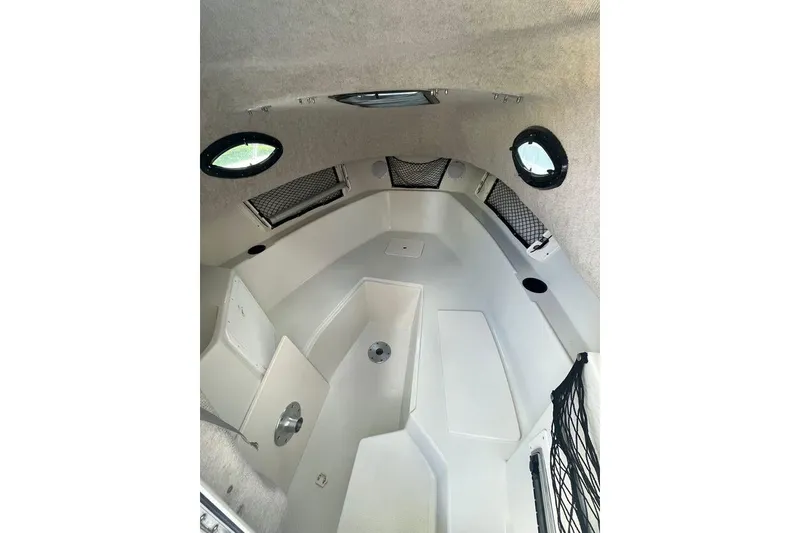 Slide: The Image of 2005 Sailfish 218 WAC cabin interior with storage nets and portholes. - 7
