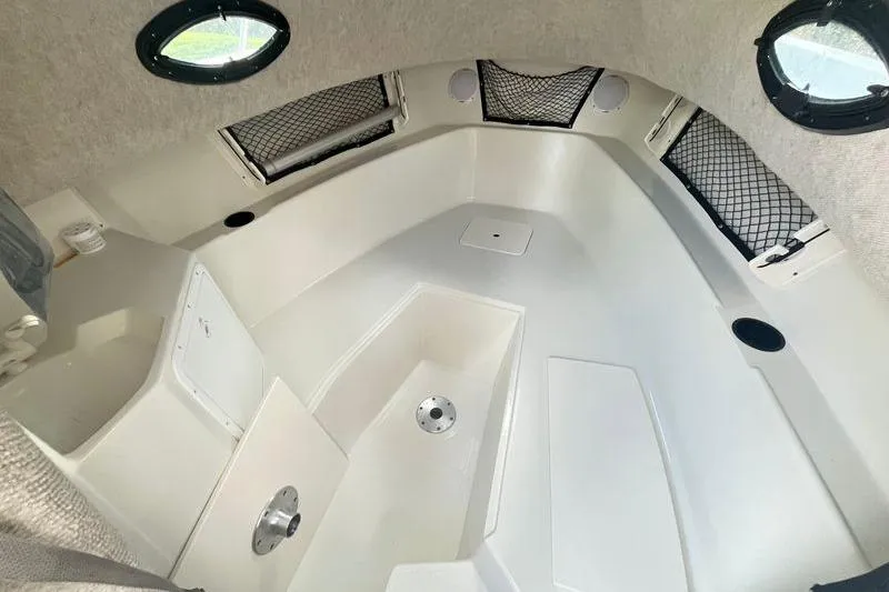 Slide: The Image of 2005 Sailfish 218 WAC cabin interior with storage nets and portholes. - 8