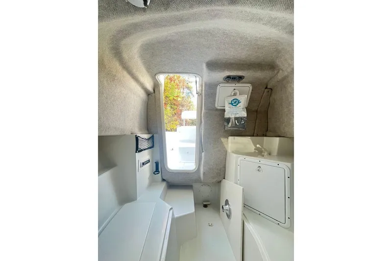 Slide: The Image of Interior cabin of 2005 Sailfish 218 WAC boat, featuring compact storage and seating. - 9