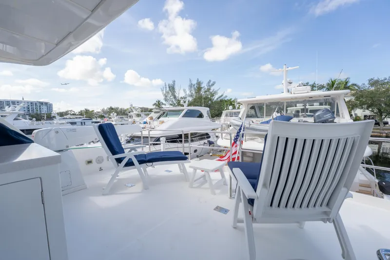 Slide: The Image of Deck view of 2016 Horizon PC52 yacht with chairs and American flag in marina. - 37