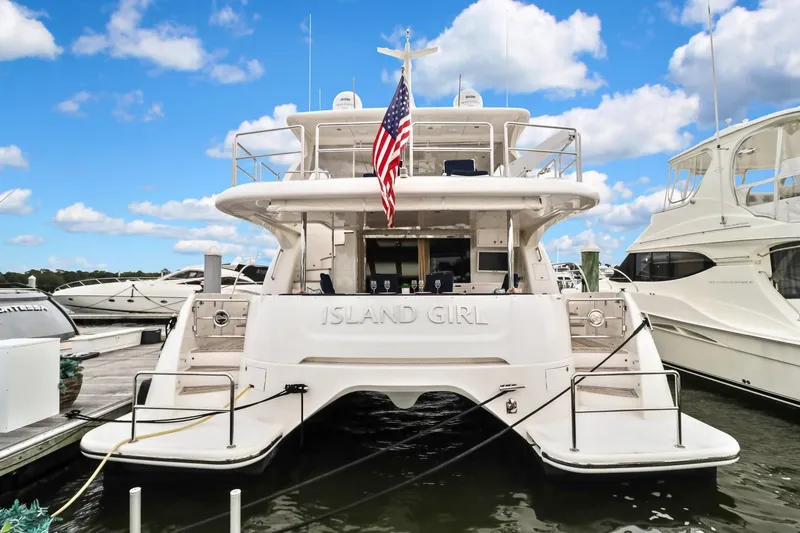 Slide: The Image of Luxury yacht "Island Girl" docked, Horizon PC52 model, 2016, with American flag, under blue sky. - 42