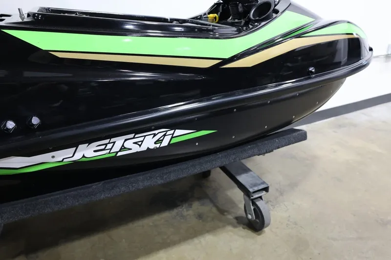 Slide: The Image of 2022 Kawasaki Jetski SX-R in black and green on a wheeled stand. - 23
