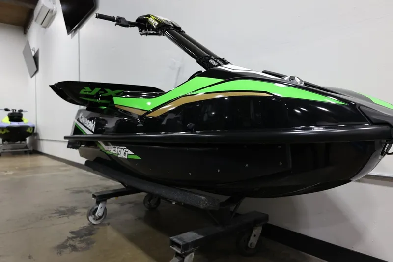 Slide: The Image of 2022 Kawasaki Jetski SX-R in showroom, black and green design, on display stand. - 24
