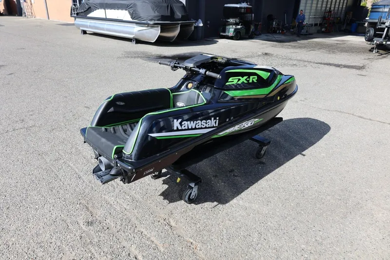 Slide: The Image of 2022 Kawasaki Jetski SX-R in black and green on a stand outdoors. - 5
