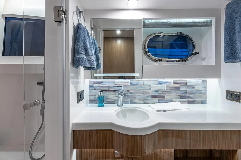 Slide: The Image of Modern yacht bathroom with sleek design, featuring a porthole window and elegant blue accents. - 17