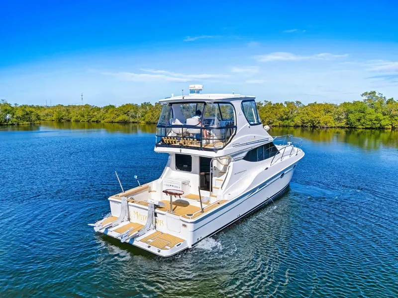 Slide: The Image of 2007 Silverton 45 Convertible yacht cruising on a serene lake under a clear blue sky. - 28