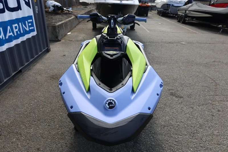 Slide: The Image of 2024 Sea-Doo Spark Trixx jet ski in vibrant green and blue, parked outdoors. - 10