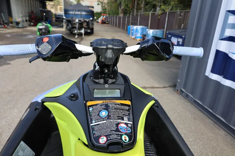 Slide: The Image of 2024 Sea-Doo Spark Trixx handlebars and controls, vibrant design, outdoor setting. - 11