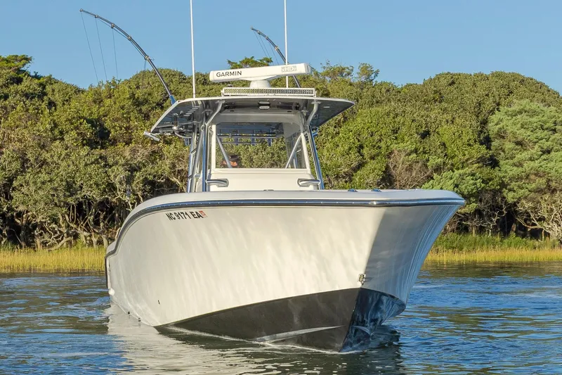 Slide: The Image of 2015 Invincible 39 Open Fisherman boat cruising near waterfront homes. - 14