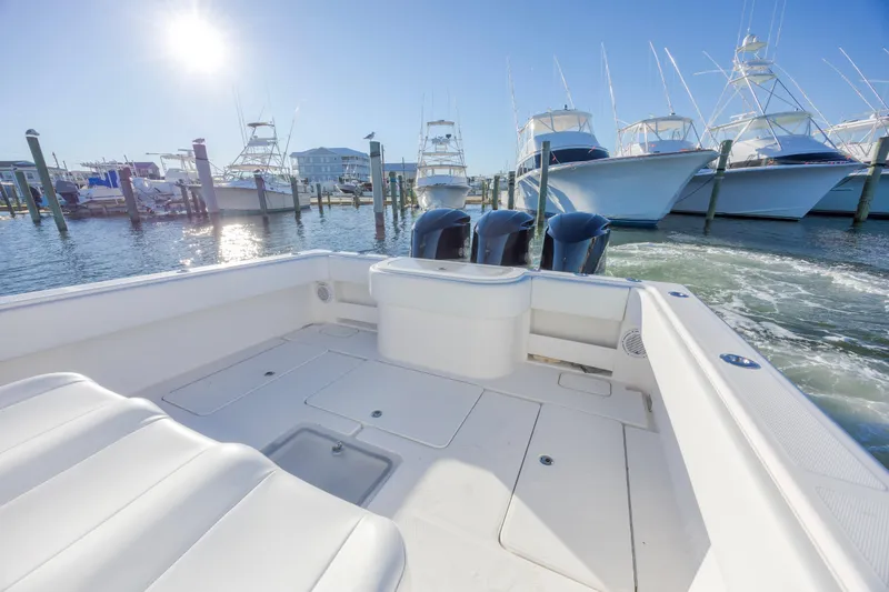 Slide: The Image of 2015 Invincible 39 Open Fisherman boat with spacious deck and seating, docked near waterfront homes. - 17
