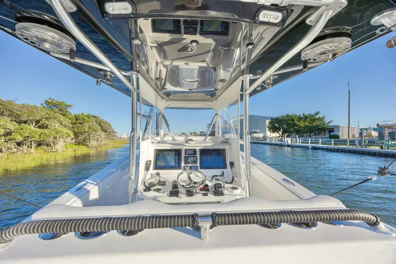 Slide: The Image of 2015 Invincible 39 Open Fisherman boat interior with white seating and clear blue sky. - 20