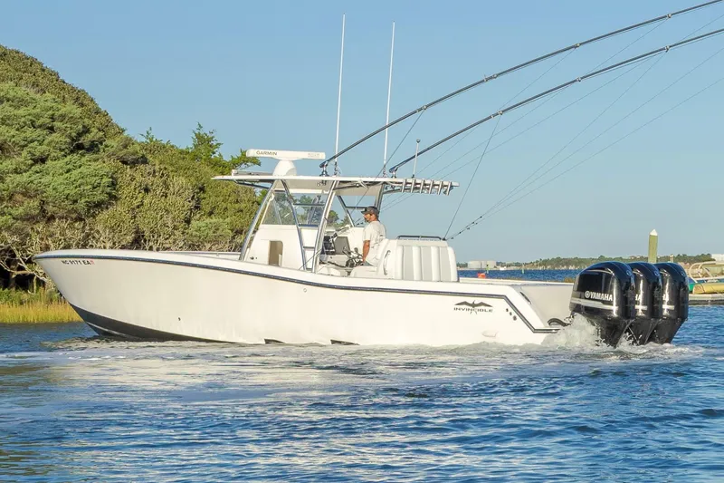 Slide: The Image of 2015 Invincible 39 Open Fisherman boat on calm water near lush greenery. - 4