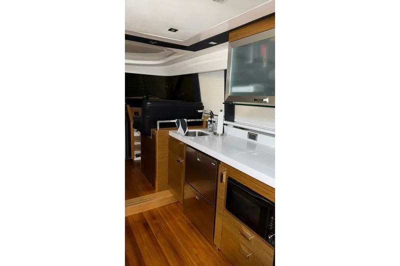Slide: The Image of Interior of 2018 Tiara Yachts C44 Coupe, featuring modern kitchen with wood accents. - 10