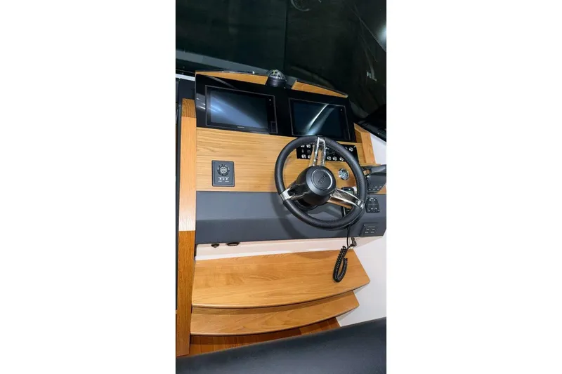 Slide: The Image of Helm of 2018 Tiara Yachts C44 Coupe with dual screens and wooden accents. - 11