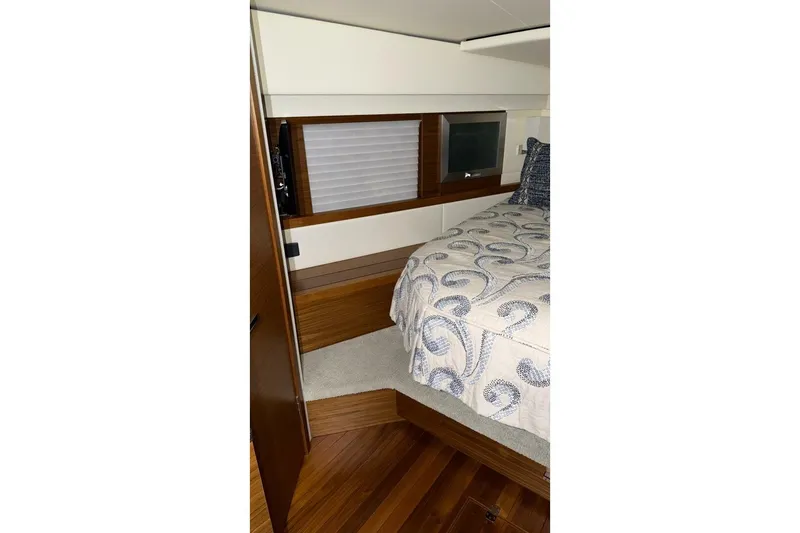Slide: The Image of 2018 Tiara Yachts C44 Coupe bedroom with elegant bedding and wood accents. - 15