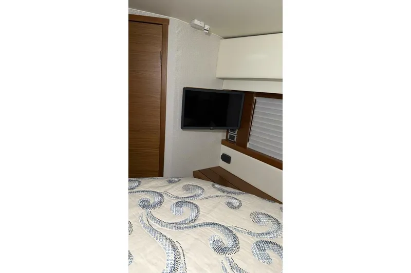 Slide: The Image of Interior of 2018 Tiara Yachts C44 Coupe with TV and patterned bedding. - 16