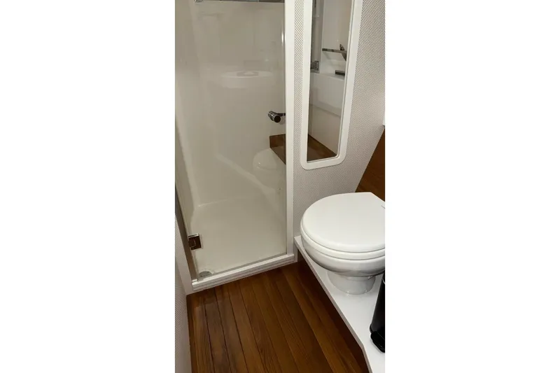 Slide: The Image of 2018 Tiara Yachts C44 Coupe bathroom with wooden flooring and modern fixtures. - 18