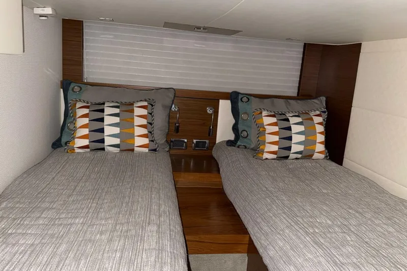 Slide: The Image of Cabin interior of 2018 Tiara Yachts C44 Coupe with twin beds and decorative pillows. - 21