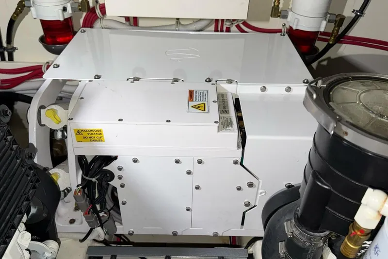 Slide: The Image of Engine room of 2018 Tiara Yachts C44 Coupe with electrical components and warning labels. - 30