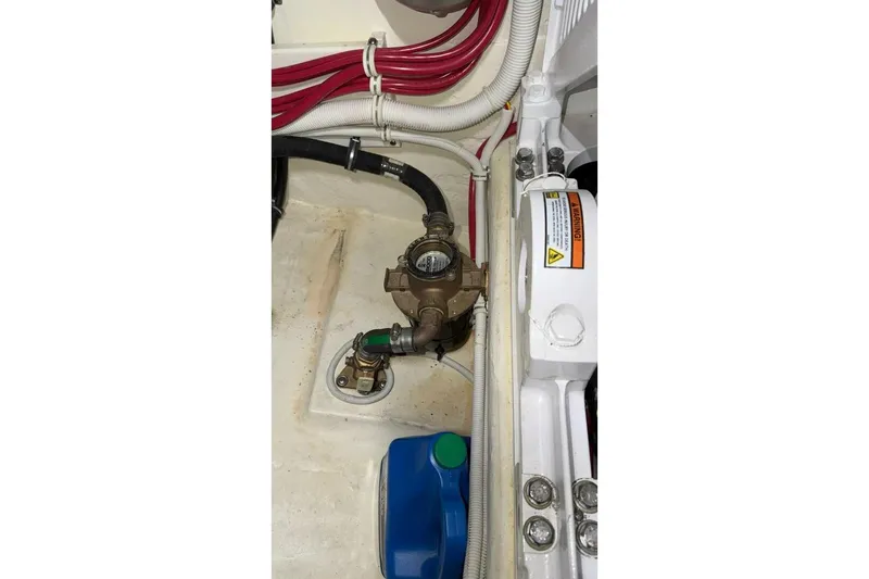 Slide: The Image of Engine compartment of 2018 Tiara Yachts C44 Coupe with visible hoses and components. - 35