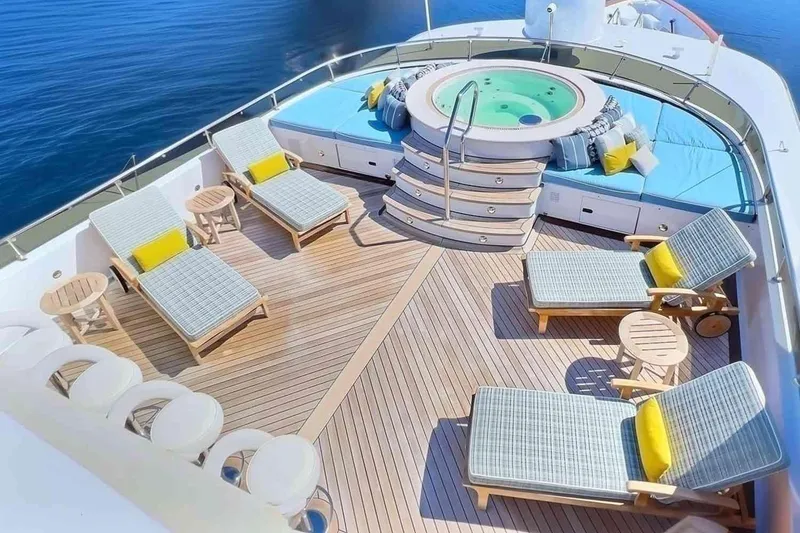 Slide: The Image of Luxurious 2003 Trinity Yachts motoryacht deck with jacuzzi, sun loungers, and ocean view. - 28