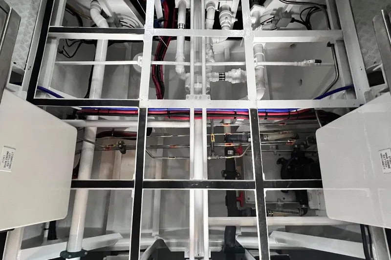 Slide: The Image of Engine room of 2003 Trinity Yachts Motoryacht, showcasing intricate piping and wiring systems. - 34