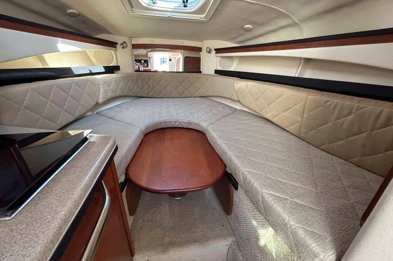 Slide: The Image of 2007 Sea Ray 260 Sundancer cabin interior with cozy seating and wooden table. - 10