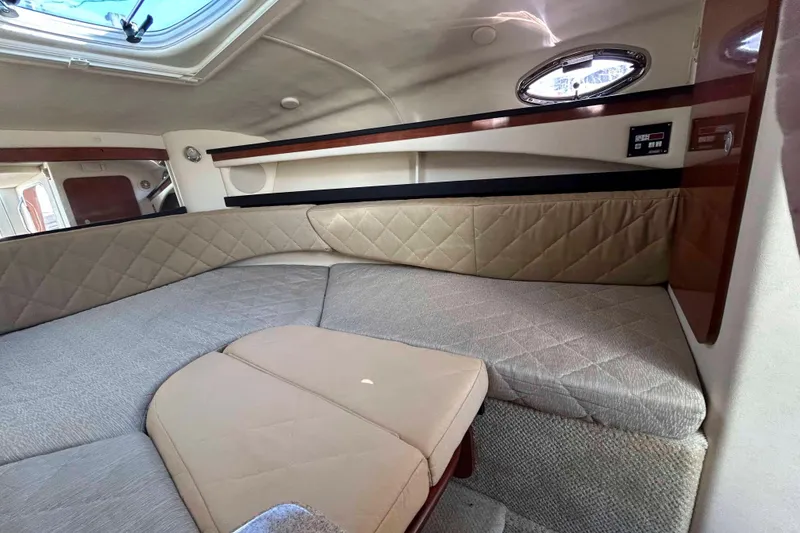 Slide: The Image of 2007 Sea Ray 260 Sundancer cabin interior with beige upholstery and porthole window. - 13