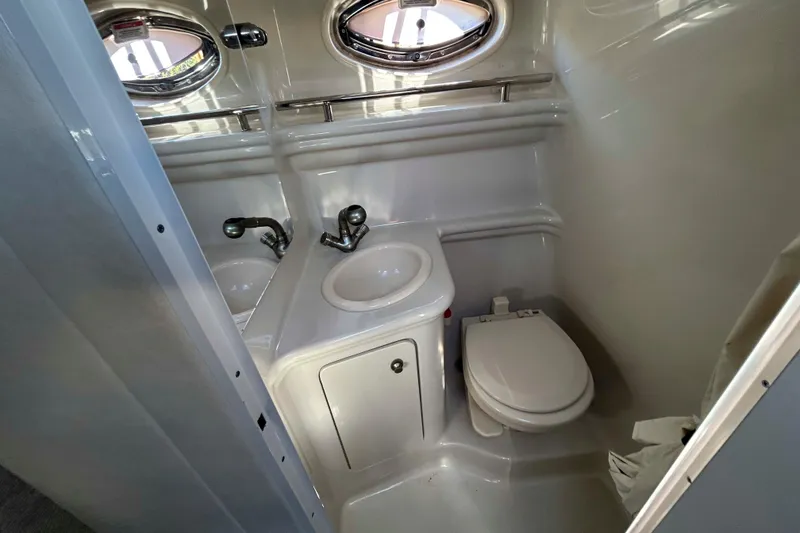 Slide: The Image of 2007 Sea Ray 260 Sundancer bathroom with sink, toilet, and porthole windows. - 18